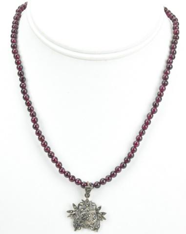 Vintage Garnet Marcasite Sterling Silver Necklace: Vintage Garnet Marcasite Sterling Silver Necklace. Having a floral motif pendant. Measures 16 inches in length.