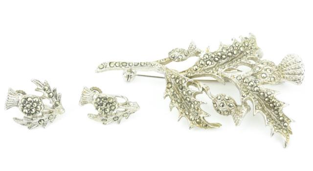 Scottish Silver & Marcasite Thistle Jewelry Suite: Scottish Silver & Marcasite Thistle Jewelry Suite. Brooch and pair of screw back earrings. Brooch measures 2.75 inches in length.