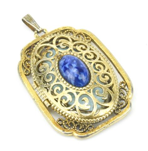 Costume Jewelry Lapis Lazuli Glass Locket Pendant: Costume Jewelry Lapis Lazuli Glass Locket Pendant. Gilt metal and lapis glass cabochon. Measures 2.5 inches in length.