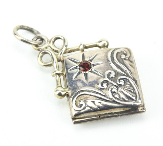Estate Sterling & Garnet Locket Necklace Pendant: Estate Sterling & Garnet Locket Necklace Pendant. Hallmarked. Starburst setting with garnet at center. Measures 1.5 inches in length.