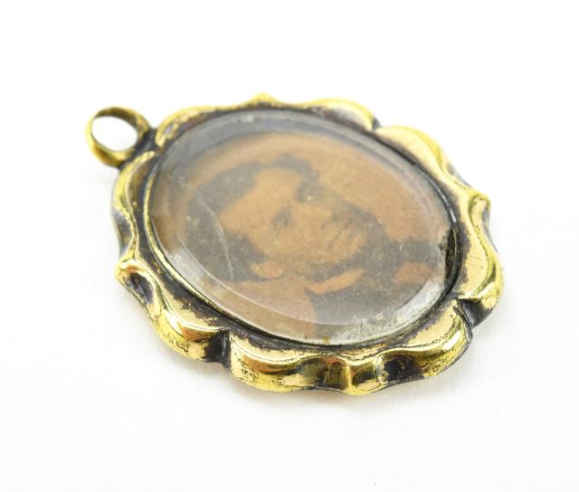 Antique 19th C 10kt Gold Mourning Locket Pendant: Antique 19th C 10kt Gold Mourning Locket Pendant. Chased 10kt gold panel on the front with floral motif. Photograph under glass on the back. Front panel acid tests as 10kt gold. Measures 1 inch in len