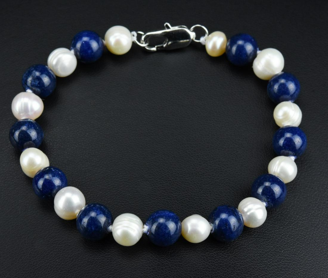 Hand Knotted Lapis Lazuli Baroque Pearl Bracelet: Hand Knotted Lapis Lazuli & High Luster Baroque Pearl Bracelet. Hand knotted on white silk thread. Measures 7.75 inches in length.