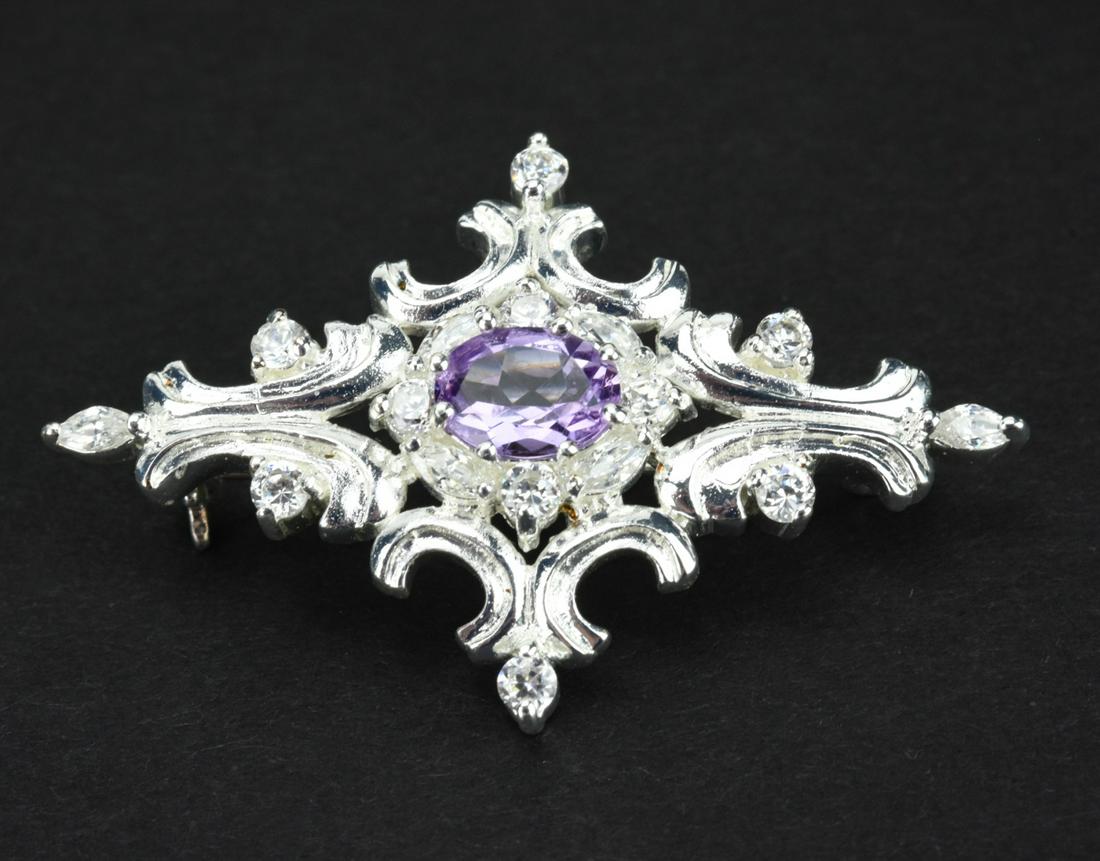Edwardian Style Sterling Silver & Amethyst Brooch: Edwardian Style Sterling Silver & Amethyst Brooch. Hallmarked. Center stone tests as amethyst on the Presidium. Measures 1.75 inches in width.