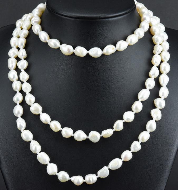Opera Length Hand Knotted Baroque Pearl Necklace: Opera Length Hand Knotted Baroque Pearl Necklace. Featuring high luster baroque pearls that vary in size from approximately 6mm to 8mm in length. Hand knotted on white silk thread, necklace measures a