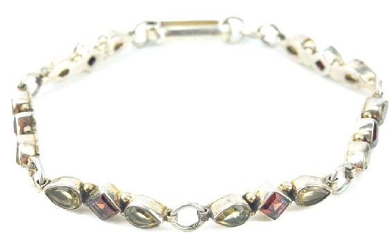 Sterling Silver Garnet & Peridot Panel Bracelet.: Articulated sterling silver bracelet w bezel set peridot and garnet. Measures just over 7.5 inches in length. Hallmarked.