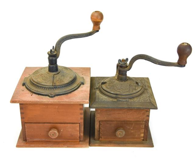 2 Antique Cast Iron & Wood Coffee Grinders: 2 Antique Cast Iron & Wood Coffee Grinders. Coffee grinders feature an upper grinding mechanism with a lower pull out drawer. Also features tongue in groove construction. Larger measures 11 inches hig