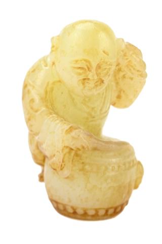 19th C. Qing Dynasty Upright Boy Beating on a Drum: 19th Century Qing Dynasty Upright Boy Beating on a Drum. A pale yellow celadon with russet inclusions