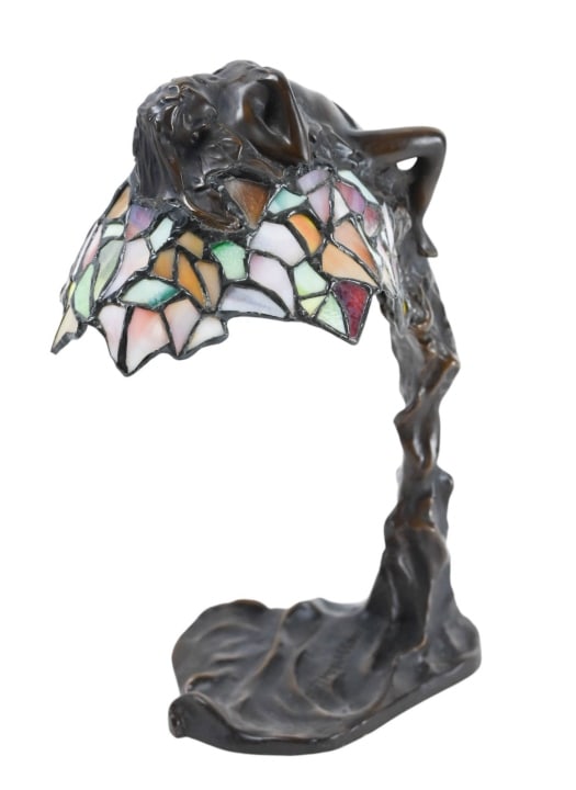 E. Thomasson Art Nouveau Bronze Daphne Lamp: E. Thomasson Art Nouveau Bronze Daphne Lamp. Depicts greek goddess Daphne in repose, draped over leaded stained glass shade.Measures 12 inches x 6.5 inches x 8 inches.
