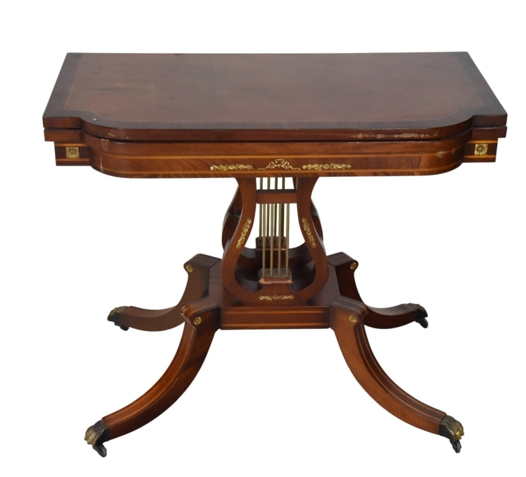 American Classical Carved Lyre Base Card Table: American Classical Hand Carved Mahogany Lyre Base Card Table. There are some scratches and damage. Sold as is.Measures 29 inches x 35.5 inches x 18 inches.
