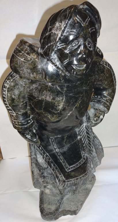 Vintage Inuit Stone Statue of Man: Vintage Inuit stone statue of man. Several small chips, 13" L x 12" W x 24" H. From the home of Mary Rockefeller.