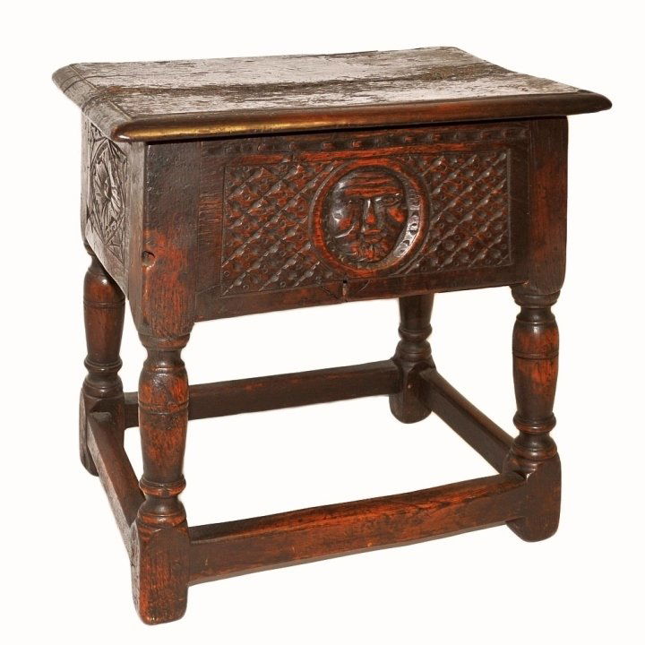 17th C. Ornate German Carved Oak Storage Stool: A 17th century ornate German carved storage stool with depiction of he Sun with a man's face. 18" W x 12" D x 17" H. Very good antique condition.