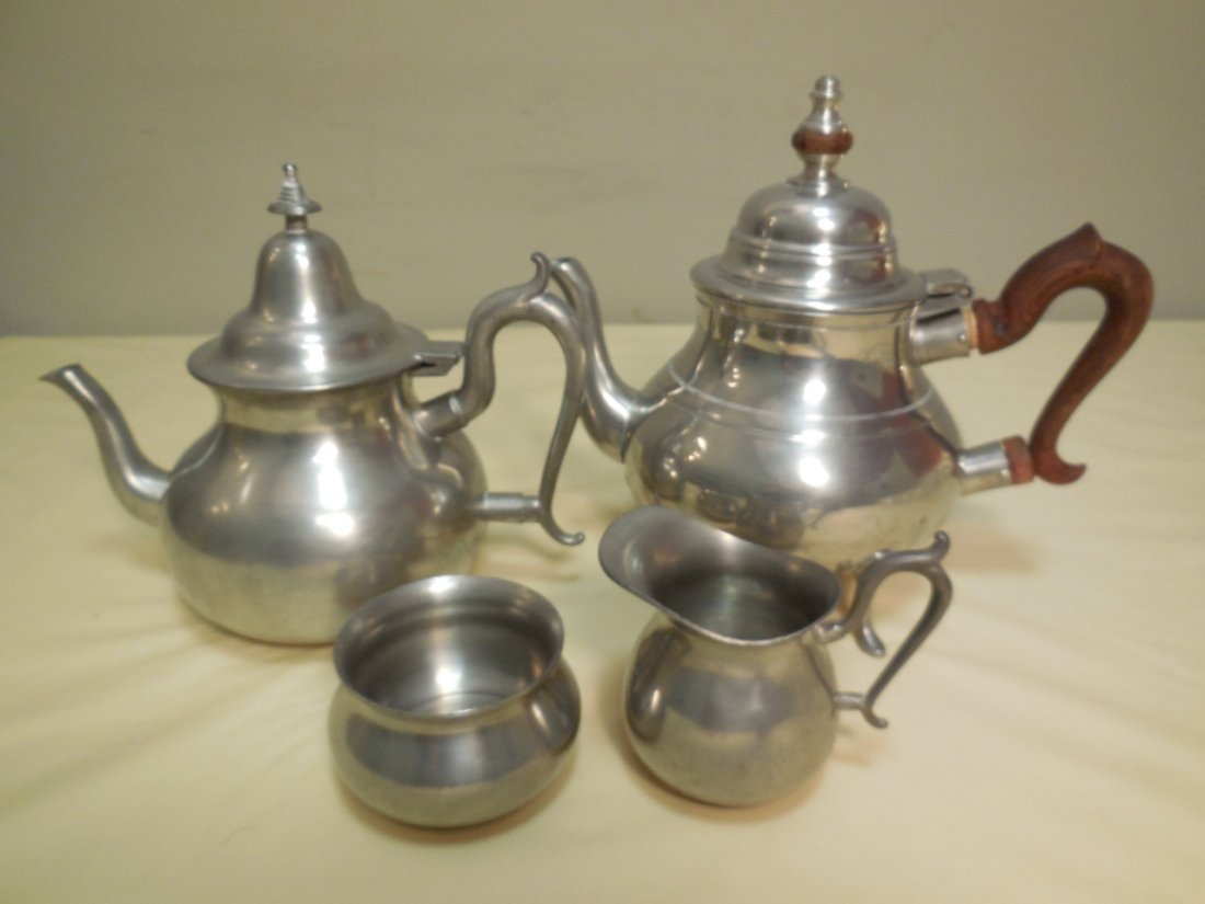 Lot of Stieff and Woodbury Pewter Tea Set Pieces: Lot of pewter tea set pieces. A Stieff pewter teapot from the Colonia Williamsburg Collection 9 1/" W x 6" D x 8 3/4" H. A Woodbury pewter teapot with creamer and sugar bowl. Teapot measures 9 1/4" W