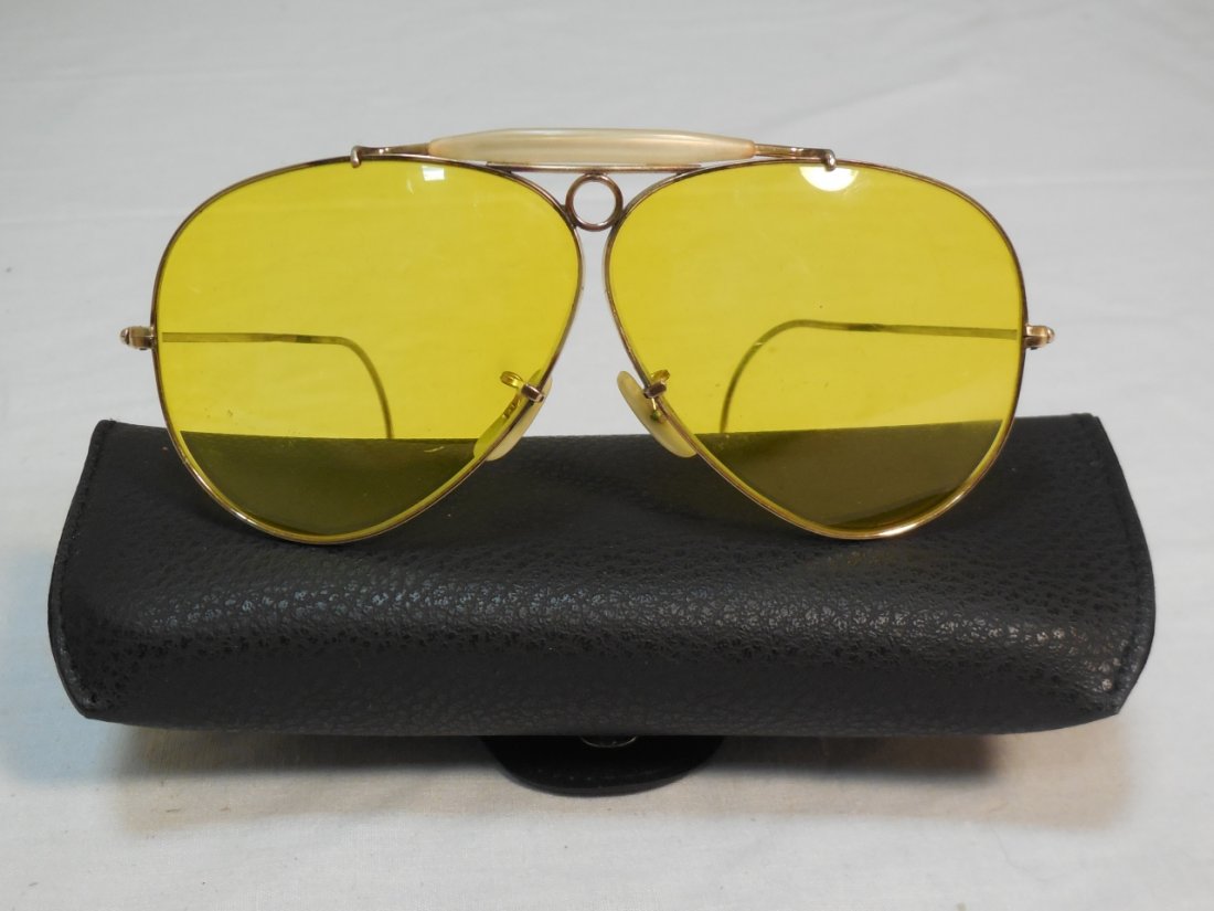 Pair of WW II Fighter Pilot Ray Ban Glasses: A pair of WW II fighter pilot Ray Ban glasses with amber lens and 10 kt. gold filled frame. 61/2" L. Good vintage condition (case not original)