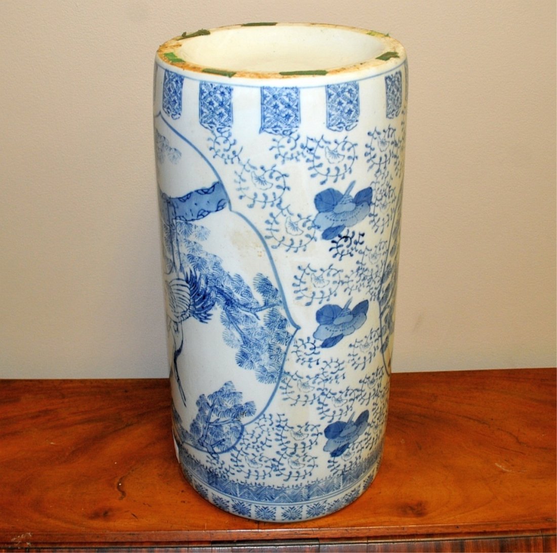Chinese Blue & White Glazed Umbrella Stand: Vintage Chinese porcelain umbrella stand with blue and white glazed design of cranes & foliage. Sleeve vase form. Measures 17.5" high by 8.75" wide. Fair to good condition with some very light "tea" s