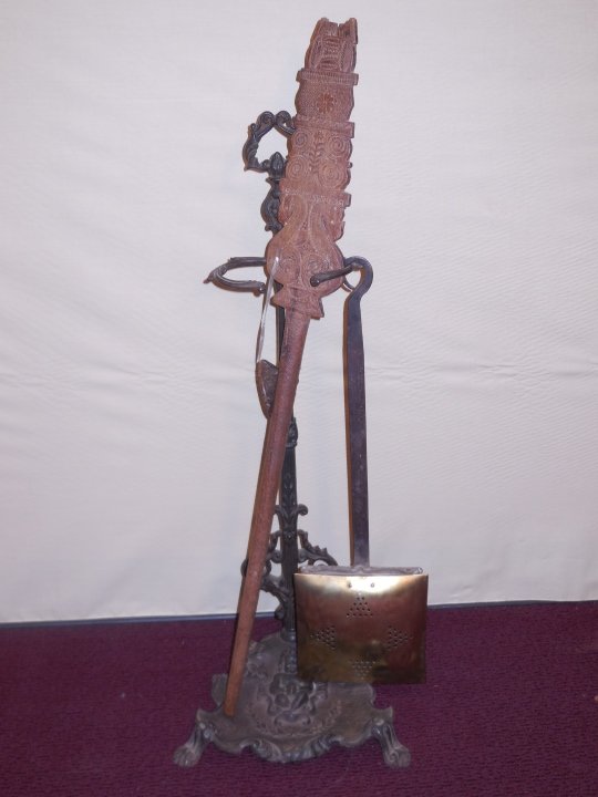 Lot of Three Antique Items: A lot of three antique items. A wrought iron fire place tool holder, 10 3/4" W x 10" D x 27 1/2" H. A Greek carved wood yard winder tool with spool, 3 1/2" L. A brass and iron chestnut roaster or bed