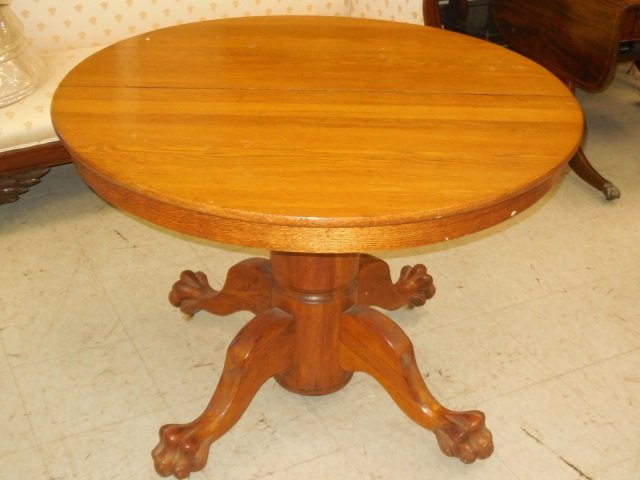Single Pedestal w/4 Feet Round Dining Table: Single pedestal round oak table with lion paw feet. 42" diameter x 29 3/4" H. Needs some refinishing.