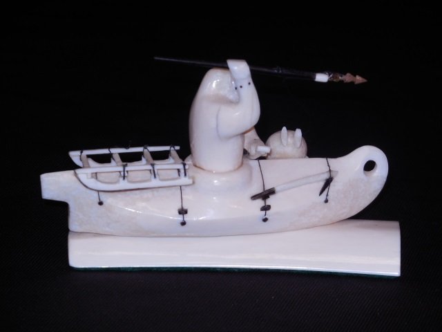 Carved Stone Inuit Hunter in Canoe: Carved stone Inuit spear hunting in a canoe. 5" W x 1 3/4" D x 3 1/8" H. In Excellent condition.