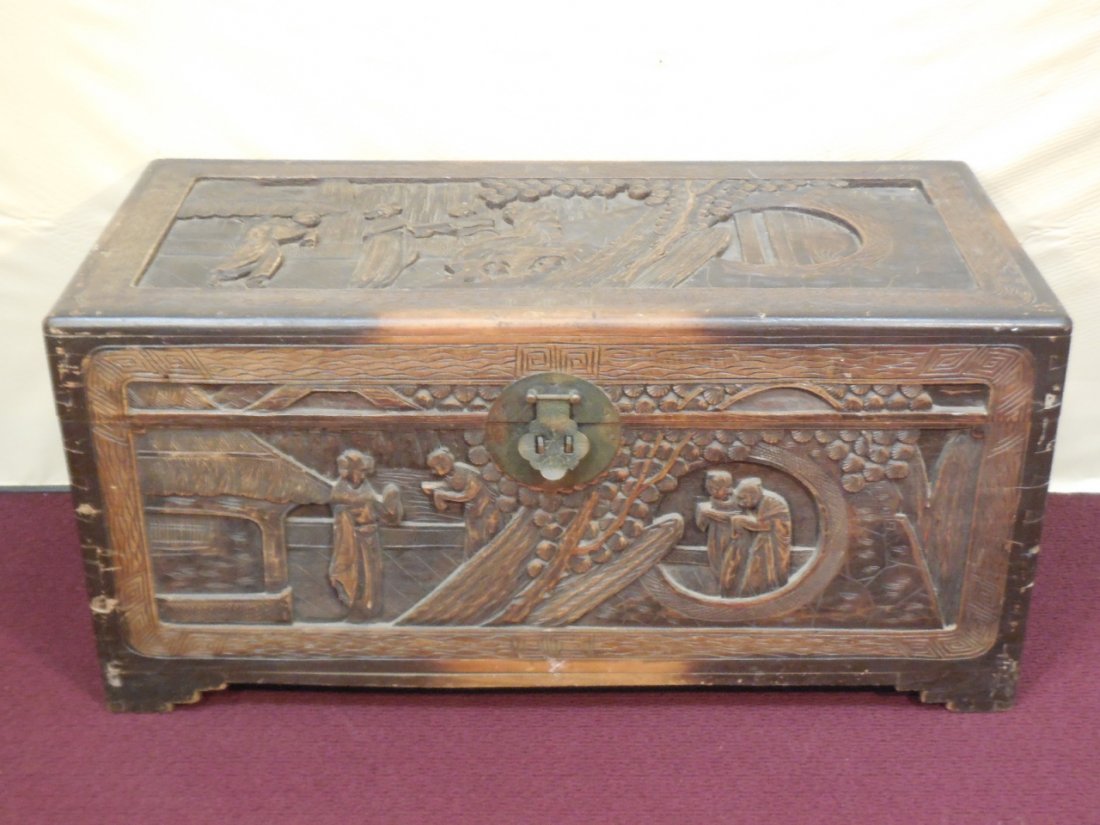 Vintage Asian Carved Wood Trunk: Vintage Asian carved wood trunk. Antique brass hardware. Carvings depict domestic daily life. 39 1/2" W x 18" D x 17 5/8" H. In good original condition.