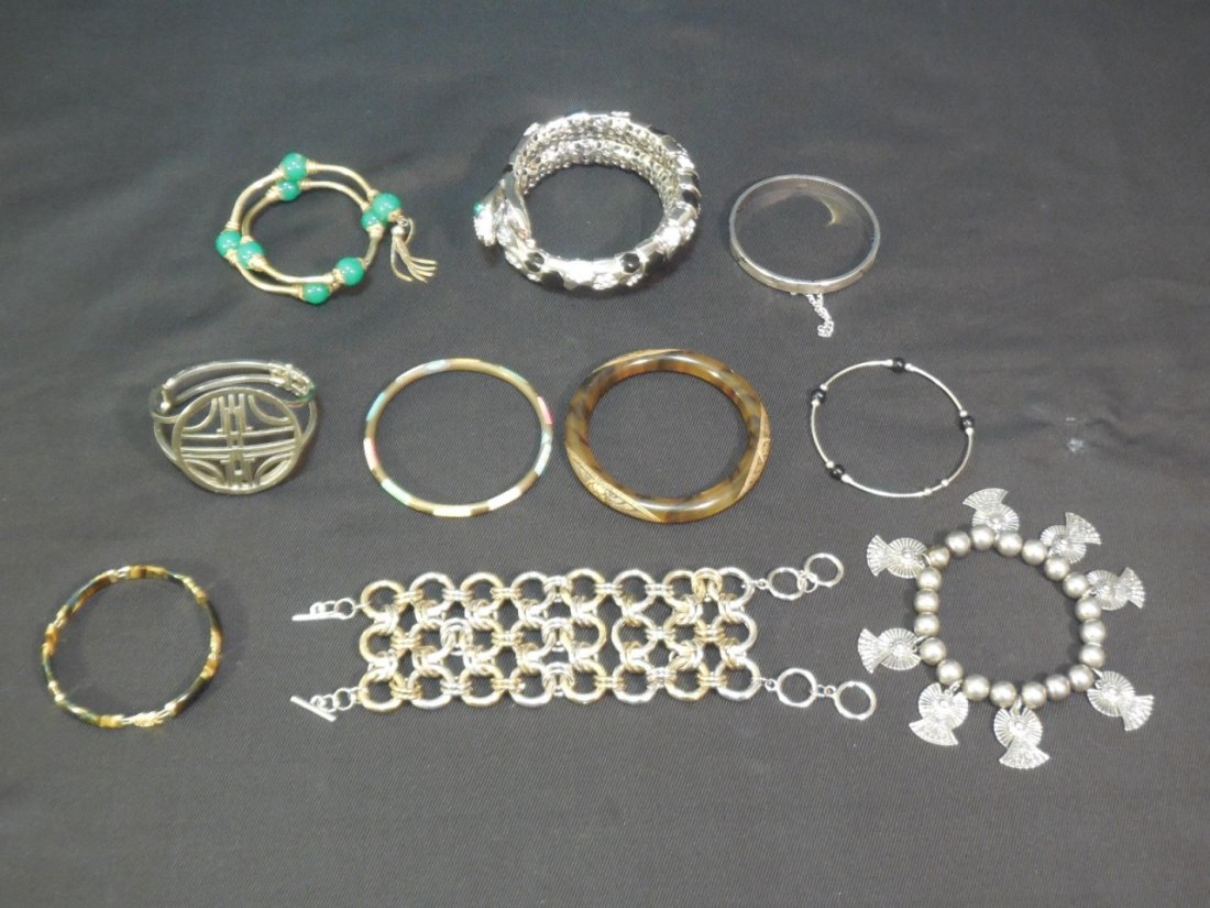 Lot of 10 Assorted Vintage Bracelets: Lot of 10 assorted vintage bracelets: Adjustable snake with stones, 3 1/2" D Metal bead with charms, 2 3/4 D Gold tone with green beads, 2 3/4" D 3 assorted, 3" D largest Amber bangle with etched desi