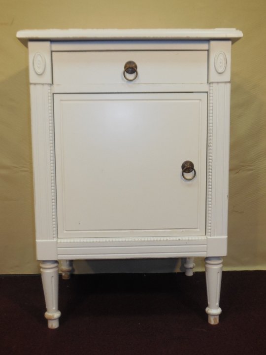 Louis XV Nightstand Cabinet w/ Single Drawer: Single white painted nightstand with one drawer and cabinet. Rosette and beadwork detail. 20" W x 17" D x 28" H. Major paint loss on top, otherwise good condition.