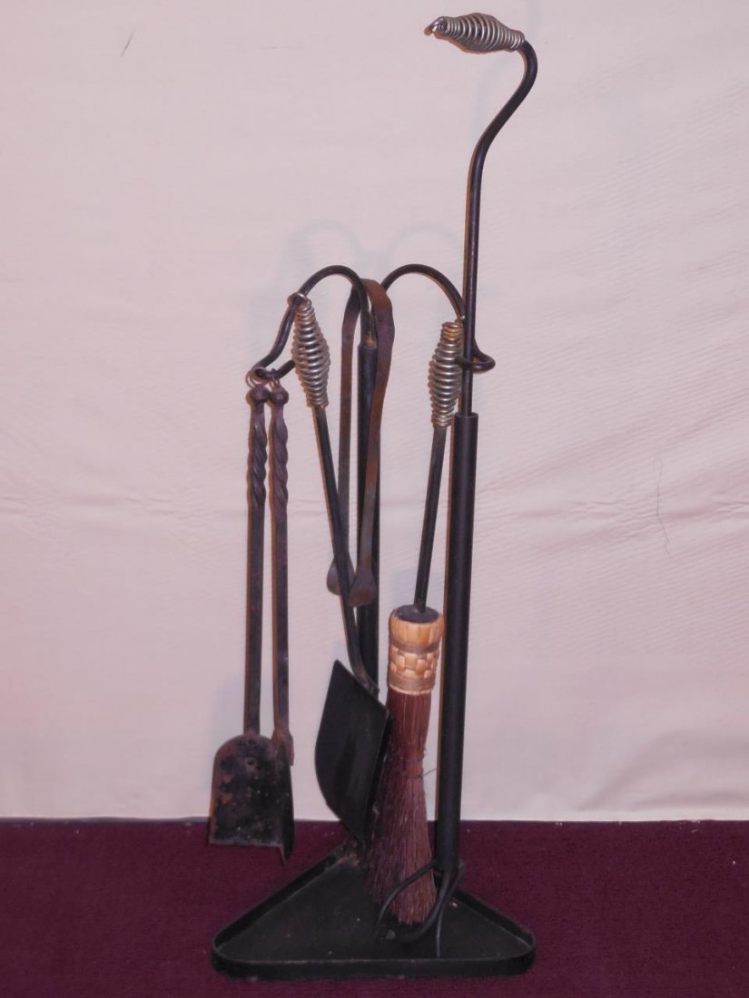 Set of 6 Iron Fireplace Tools with Spiral Handles: Set of six black iron fireplace tools with stand, some rust. Spiral wire detail on handles. Set includes the following; two small shovels, one large shovel, one brush, one pair of tongs and a poker. 3