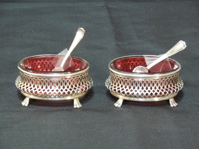 Sterling Silver & Cranberry Glass Salt Cellars: Sterling Silver and cranberry glass salt and pepper cellars with spoons. 2 1/2" W 2" D x 1" H. In excellent condition.