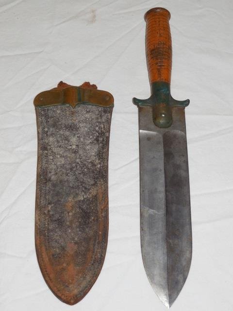 US Springfield Wood Handle Dagger w/Sheath: A US Springfield double edged wooden handle dagger with leather/metal sheath. 2 1/2" W x 1 1/2" L. Good condition, sheath has some discoloration.