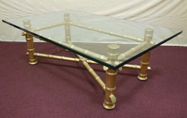 Hollywood Regency Gilt Bamboo Coffee Table: Coffee table with glass top, wood base. Base is painted gold with a modern bamboo style. 48" W x 30" D x 18 1/2" H. In good condition.