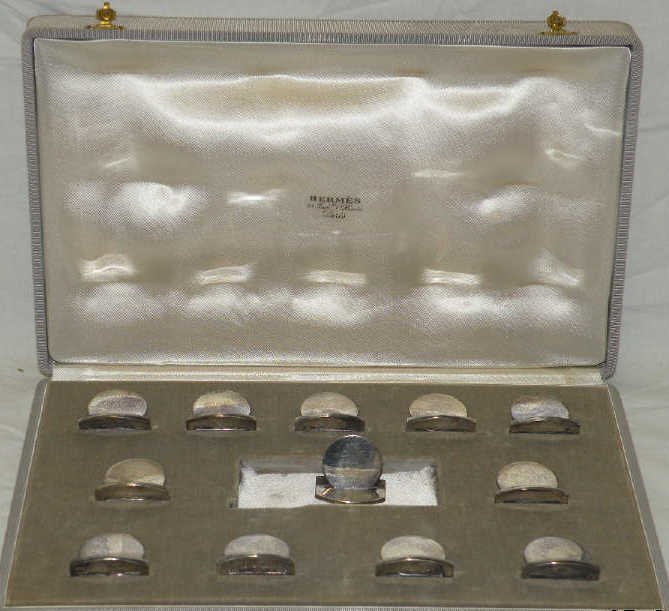 Hermes Ravinet D'Enfert Silver Place Card Holders: A set of 12 French silver placecard holders in fitted ox made for Hermes by Ravinet D'Enfert of Paris. Box and each place card holder marked for Hermes. Each having a plain base with a coin shaped car