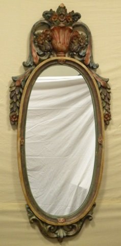 Vintage Painted Carved Wood Mirror: Vintage carved wood mirror. Hand painted. Floral motif. Oval shaped. 48" H x 23" W. In very good vintage condition. Top has a chip.