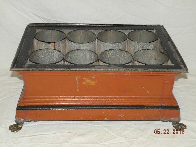 Antique Wine Caddy / Cooler Painted Metal: Antique wine caddy / cooler. Orange painted metal with black painted detail. Aluminium interior holds ten bottles. Center area may hold ice. Brass lion paw feet and handles. 20" W x 13 1/2" D x 8" H. 
