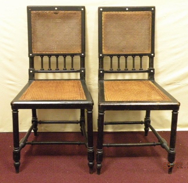 Pair Black Cane Seat & Back Side Chairs: A pair of black cane seat with cane and spindle back side chairs having decorative white rivets along frame. 16 1/2" W x 17" D x 33 1/2" H. Good condition, one chair missing upper left corner rivet..