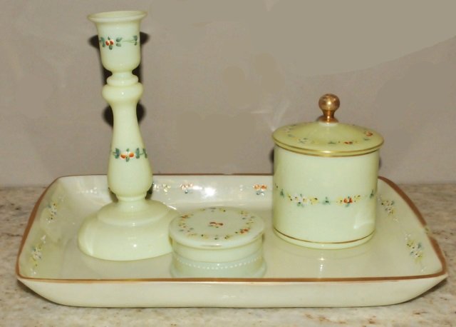 Vintage Lime Opaline Painted Vanity Set: Vintage or antique lime green opaline glass vanity set with ground edges and enamel gilt and floral paint decoration. Includes tow lidded compact jars, a candle holder and a tray. The tray has some fl