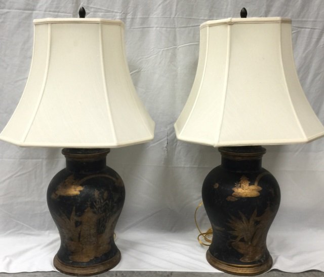 Pair Black Tole Lamps w/ Gold Asian Scene: Pair of black tole lamps decorated with gold Asian scenes. Ivory lampshades. 10" W x 34" H. In very good condition.