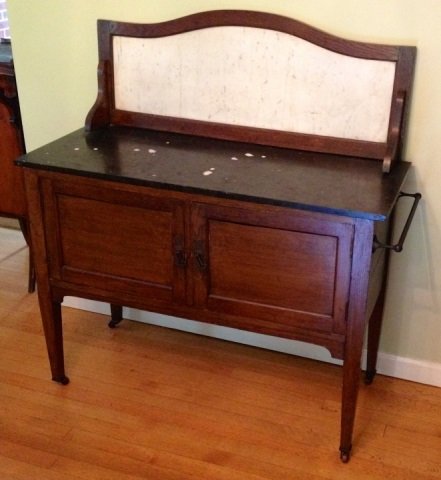 Antique English Edwardian Marble Vanity Cabinet: Antique English Edwardian marble top vanity cabinet. Marble counter and back board. Towel bar on side. Measures 46 inches in height, 43 inches in width, 17 inches in depth.
