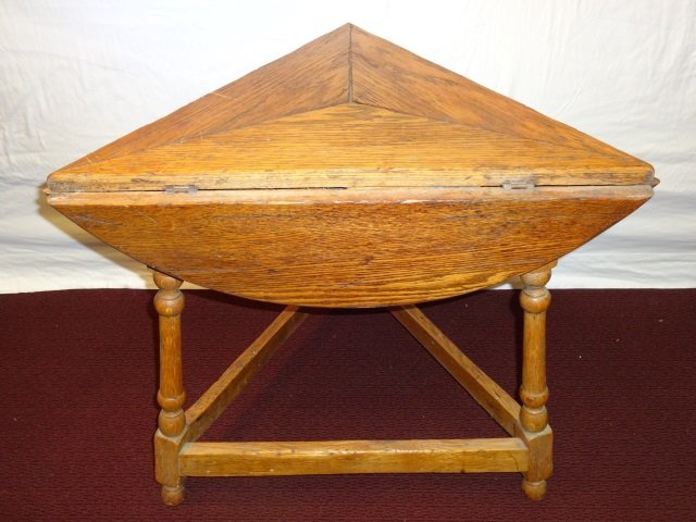 Drop Leaf Triangle Oak Seance Table: An oak three legged drop leaf triangular seance table. 27" W x 23 3/8" D x 23 3/4" H (closed), 29 3/8" dia. x 23 3/4" H. Very good condition.
