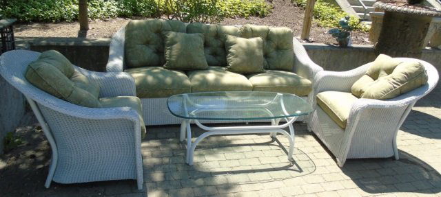 Lot of 4 Outdoor Furniture Pieces: A lot of four outdoor furniture pieces. A woven wicker three loose seat and three loose button back cushions, painted white. 83" W x 38"D x 34" H. Two woven wicker chairs 33" W x 38" D x 34" . An oval