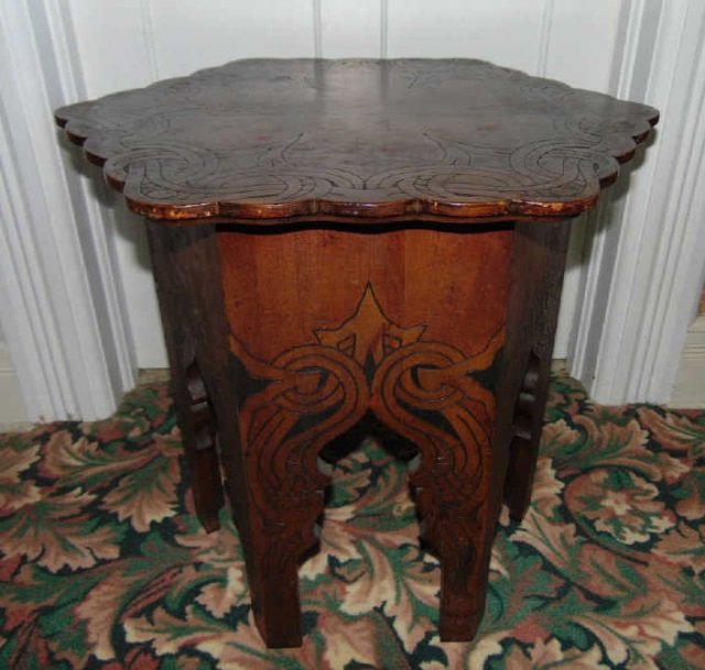 Antique Carved Wood Moroccan Style End Table: Antique Carved Wood Moroccan Style End Table. Carved Arts and Crafts style detailing. Measures 21 inches in height, 23 inches in diameter at top.