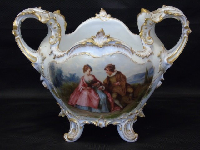 German KPM Hand Painted Porcelain Center Piece: German KPM Hand Painted Porcelain Center Piece. Signed on bottom. Hand painted scenes on front and back. Rococo gilt decorated design details. Measures 8 inches in height, 11 inches in width, 7.5 inch