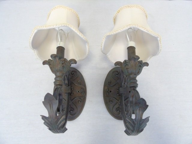 5 Wrought Iron Sconces with Scroll Detail: Five wrought iron sconces with fleur de lis and scroll detail. White cotton shade with gimp. 15" H x 6 1/2" W x 10 1/2" D. Photo shows a pair but this lot is for all 5.