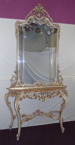 French Rococo Style Console Table w/ Mirror: French Rococo style console table with matching mirror. Elaborately carved wood subtly painted with pale pink and green with gold. Pink marble top. Console measures 53"W x 15 1/2" D x 36" H. Mirror me