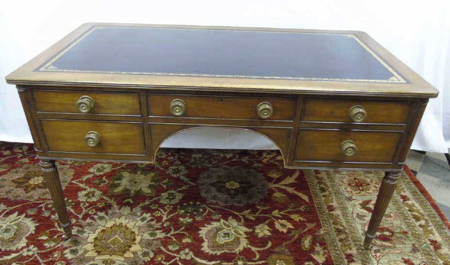 Kittinger Mahogany Desk Tooled Leather Top: Kittinger mahogany desk with gold tooled leather top. 5 drawers with antique brass knobs. Fluted legs with casters. Finished back with 2 knobs on fauxcabinets. 59" W x 29" D x 30 1/2" H.