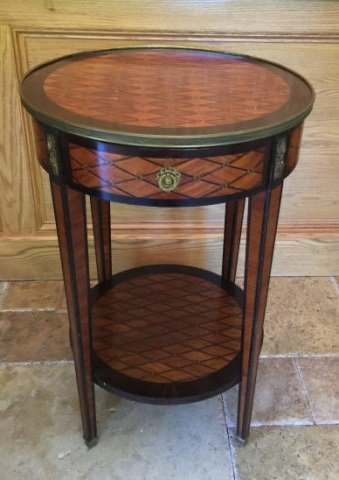 Antique French Marquetry Wood Inlay End Table: Antique French Marquetry Wood Inlay End Table. Having a detailed trompe l'oeil marquetry wood design and gilt bronze ormolu mounts. Single drawer and shelf with tapered legs. Measures 30 inches in hei