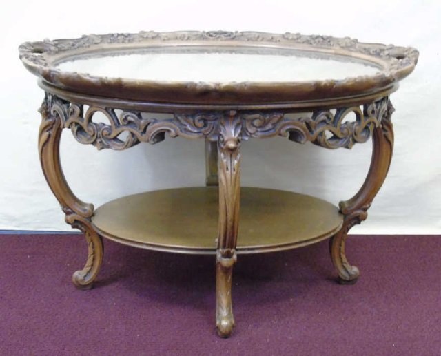 Carved Mahogany Coffee Tray Table Marquetry Top: Carved oval mahogany coffee tray table. Marquetry table top with glass. Floral carved edge. Shelf stretcher. Carved cabriole legs. 30" W x 23 1/2" D x 20" H.