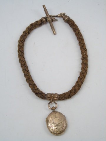 19th Cent. English Victorian Funereal Hair Locket: 19th Century English Victorian Funereal Human Hair Locket. 11 1/2" long. Gold filled locket measures 1" long.