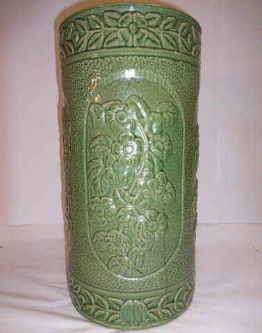 American Arts & Crafts Molded Pottery Umbrella Urn: An American Arts and Crafts molded pottery umbrella urn made by Weller. 20th century. Of cylindrical form with molded panels of poppy blossoms on stippled ground. 9 1/4" dia. x 18 1/8" H. Excellent co