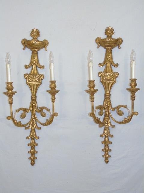 Pair Electrified Gold French Rococo Wall Sconces: Pair Electrified Gold French Rococo Wall Sconces. Each with ornate scrollwork, urn at top and two arms. Each measures 41 x 13 inches.