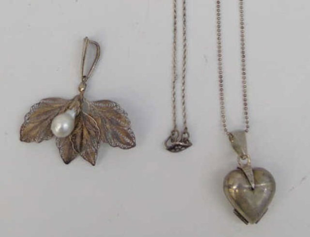 Three Estate Filigree & Sterling Silver Necklaces: Three Estate Filigree & Sterling Silver Necklaces. Filigree leaf pendant with baroque white pearl, Siam silver pendant on chain, heart locket pendant. Chains approximately 14 and 23 inches in length.