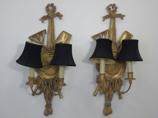 Pair Gilt Wood Electric 2 Arm Classical Sconces: Pair Gilt Wood Electric 2 Arm Classical Sconces, having wheat, rake and spade carved details, as well as Draping Ribbons. Measuring 24"h x 10" x 16".