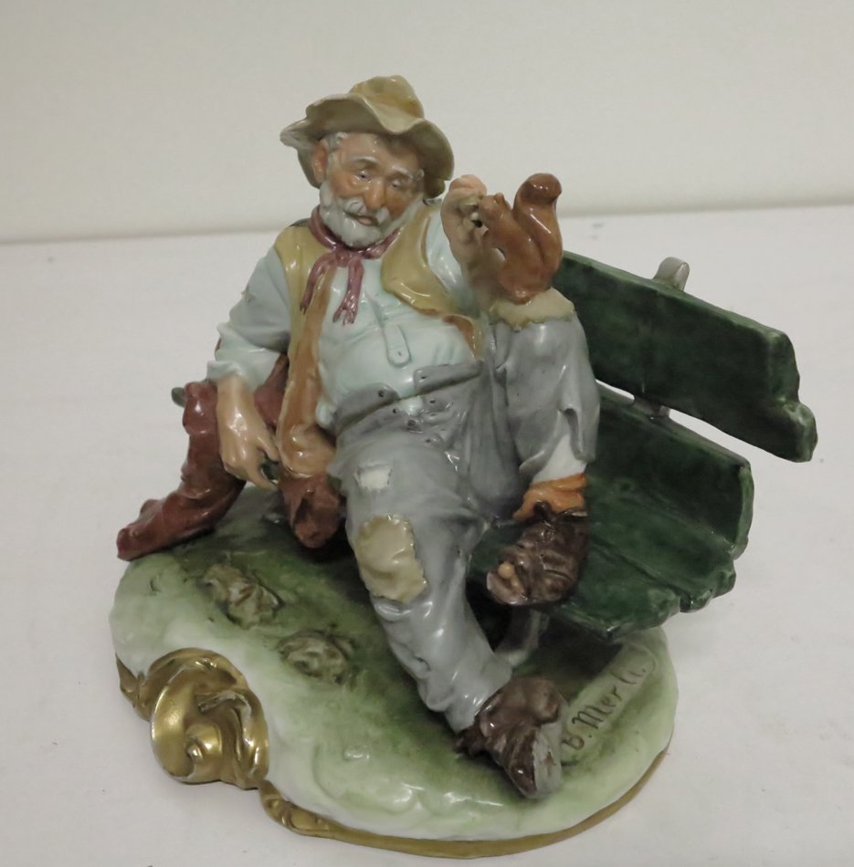 Capodimonte Man on bench with squirrel: Signed "N" Capodimonte bum on bench with squirrel. 8.5x10x6.25